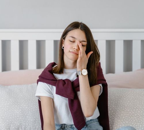 Calm child sitting cross-legged with eyes closed in a peaceful setting.